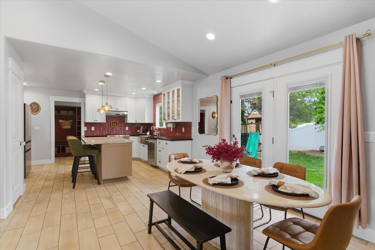 Open-concept kitchen and dining area featuring light tiled flooring and white cabinetry