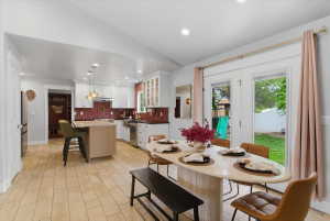 Open-concept kitchen and dining area featuring light tiled flooring and white cabinetry