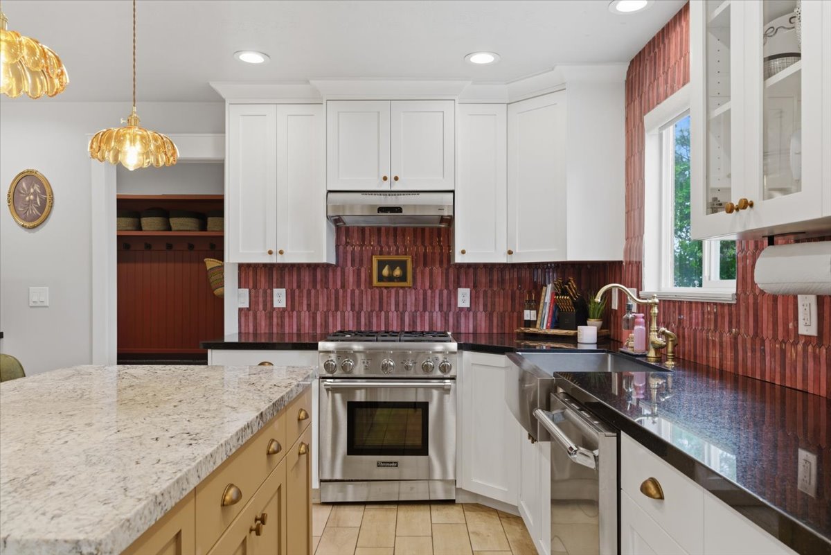 Kitchen featuring white cabinetry, stainless steel appliances, a large farmhouse sink and  granite countertops