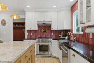 Kitchen featuring white cabinetry, stainless steel appliances, a large farmhouse sink and  granite countertops