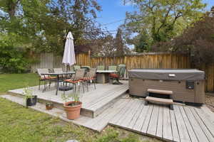 Spacious wood deck featuring a covered spa with steps