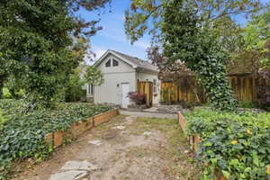 Stucco exterior residence featuring a front entry door and a decorative gable window
