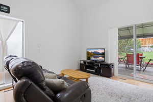 Vaulted ceilings in this bright room with wood-finish flooring
