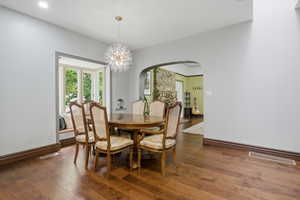 Dining area featuring wood-finish flooring, a bay window with integrated bench seating, and a modern chandelier