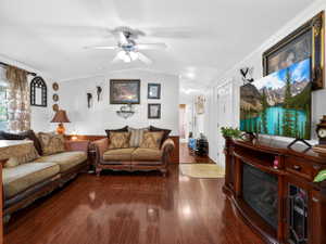 Spacious interior featuring wood-finish flooring, a ceiling fan with integrated lighting, and crown molding