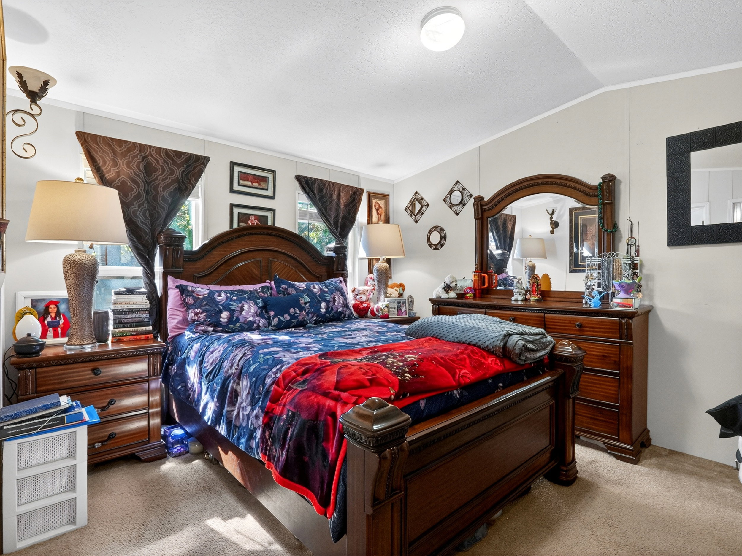 Carpeted bedroom featuring multiple windows, a ceiling-mounted light fixture, and light-toned walls