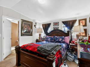 Bedroom featuring a paneled accent wall, carpet flooring, and a ceiling light fixture