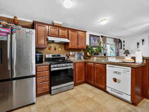 U-shaped kitchen featuring wood-finish cabinetry, a stainless steel range, and a dual-basin sink