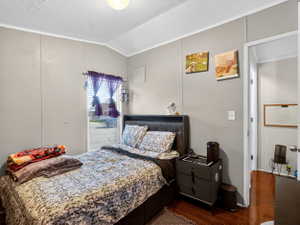 Bedroom featuring wood-finish flooring and light gray panel walls