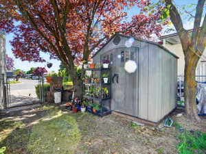 Freestanding storage shed with wood-look siding and arched double doors