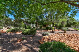 Lush, mature trees frame the property, offering natural shade