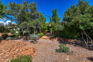 Landscaped front yard featuring mature trees and various plantings