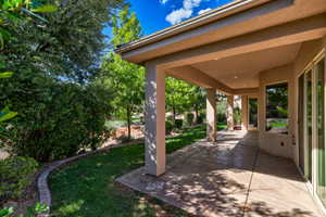 Spacious covered patio featuring textured concrete flooring, recessed lighting, and multiple access points to the interior