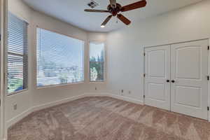 Carpeted room with a bay window configuration, featuring multiple windows with blinds