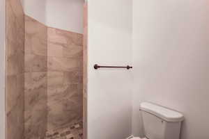 Walk-in shower featuring large format tile walls and a mosaic tile floor