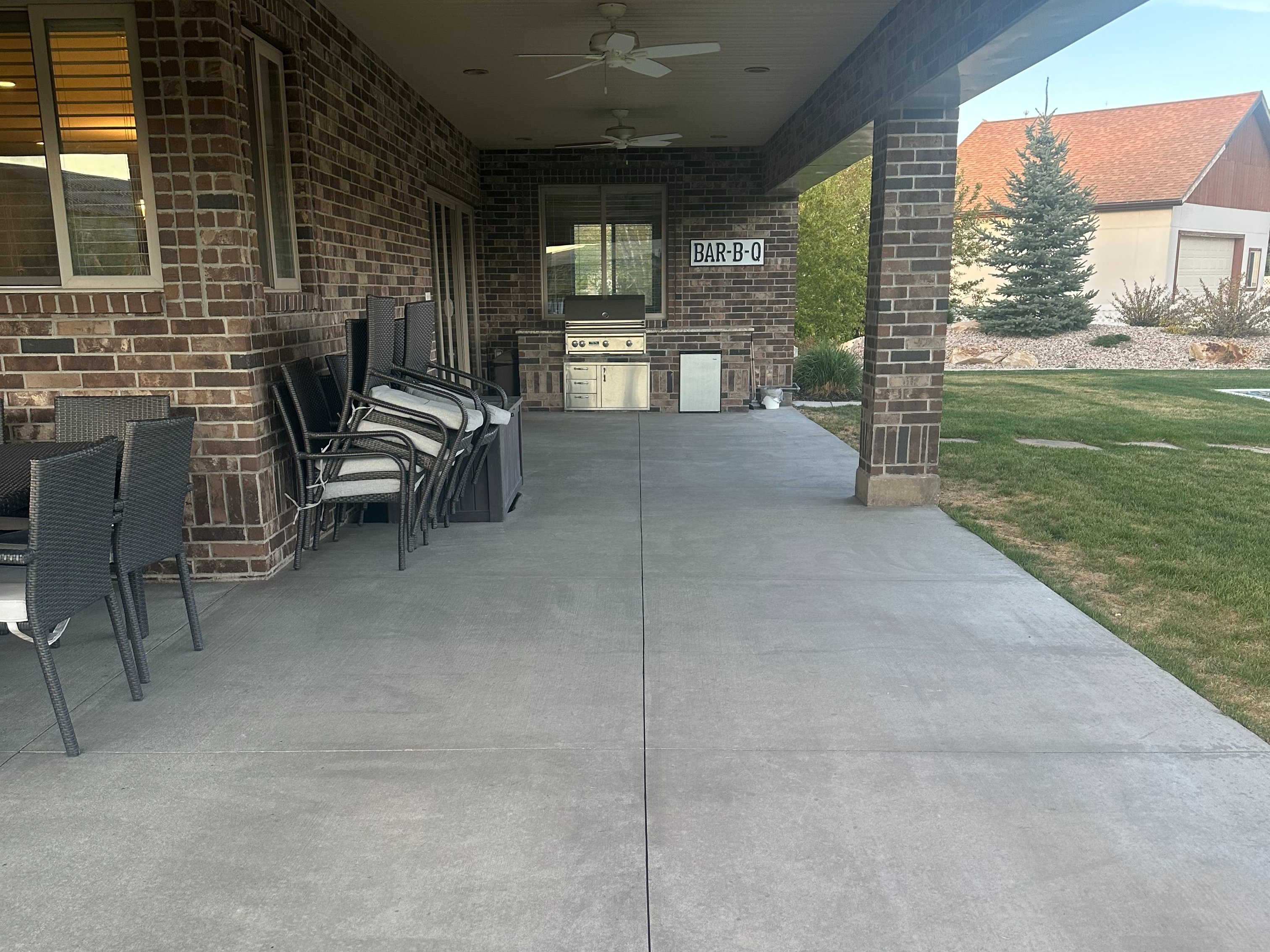 Covered patio featuring an outdoor kitchen with built-in grill, brick facade, recessed lighting, and ceiling fans