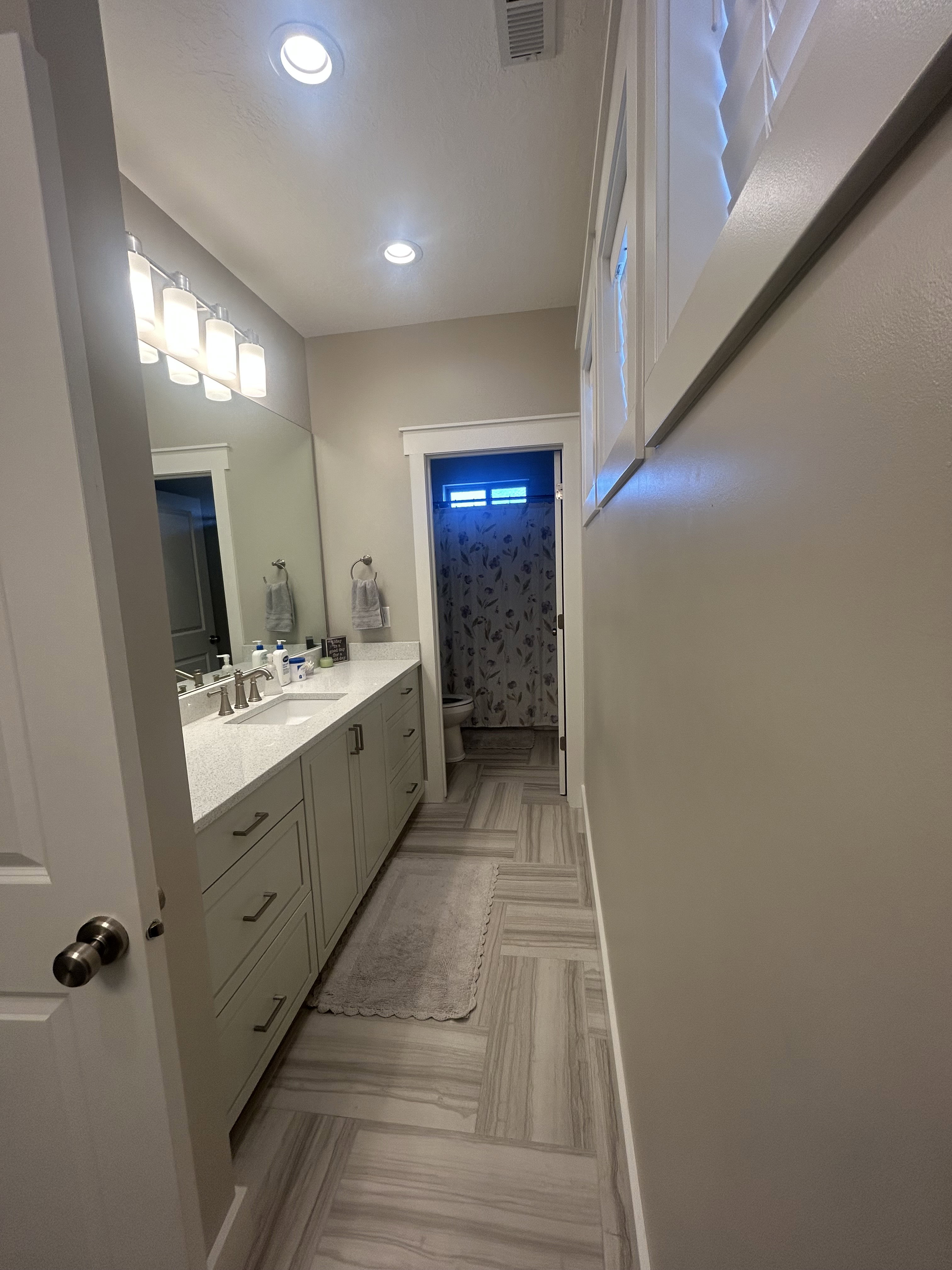Bathroom featuring a spacious dual vanity with light-toned cabinetry and a light-colored countertop