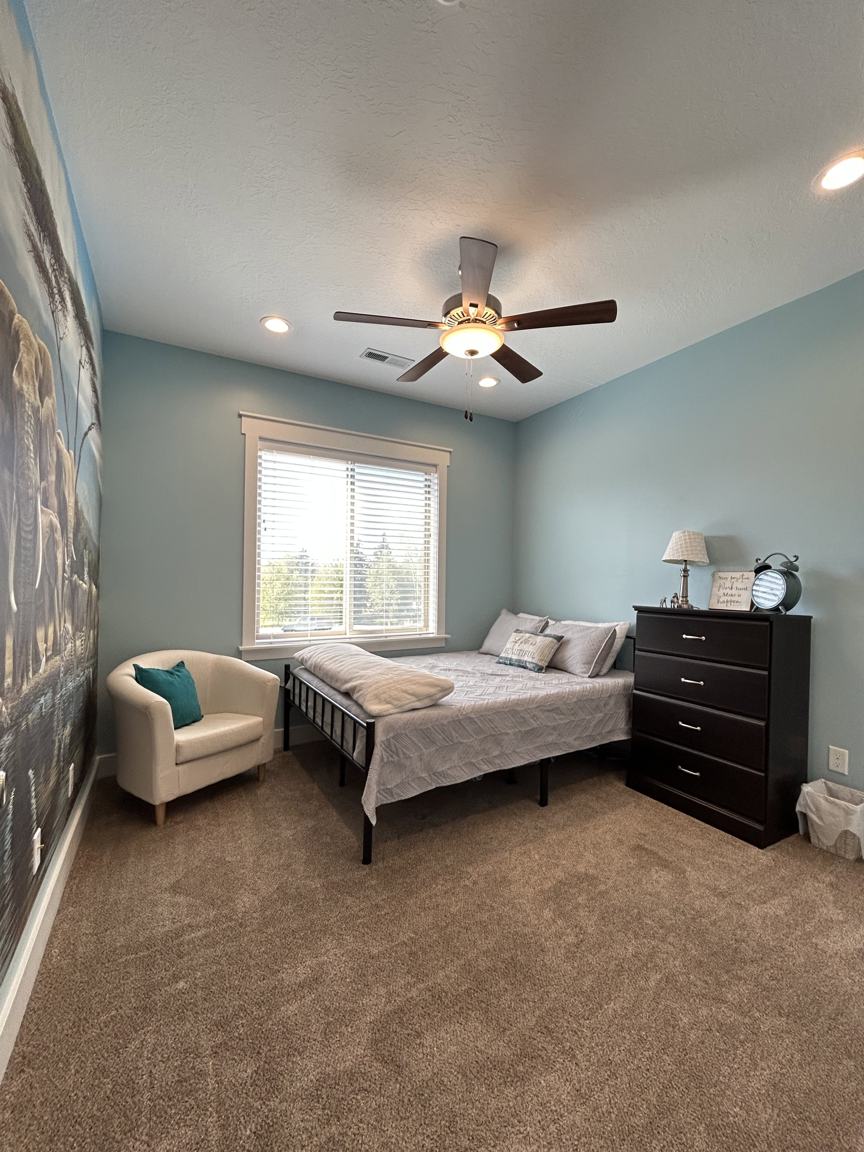 Expansive room featuring plush carpeting, a large window with white blinds, a ceiling fan with integrated lighting, and recessed ceiling lights
