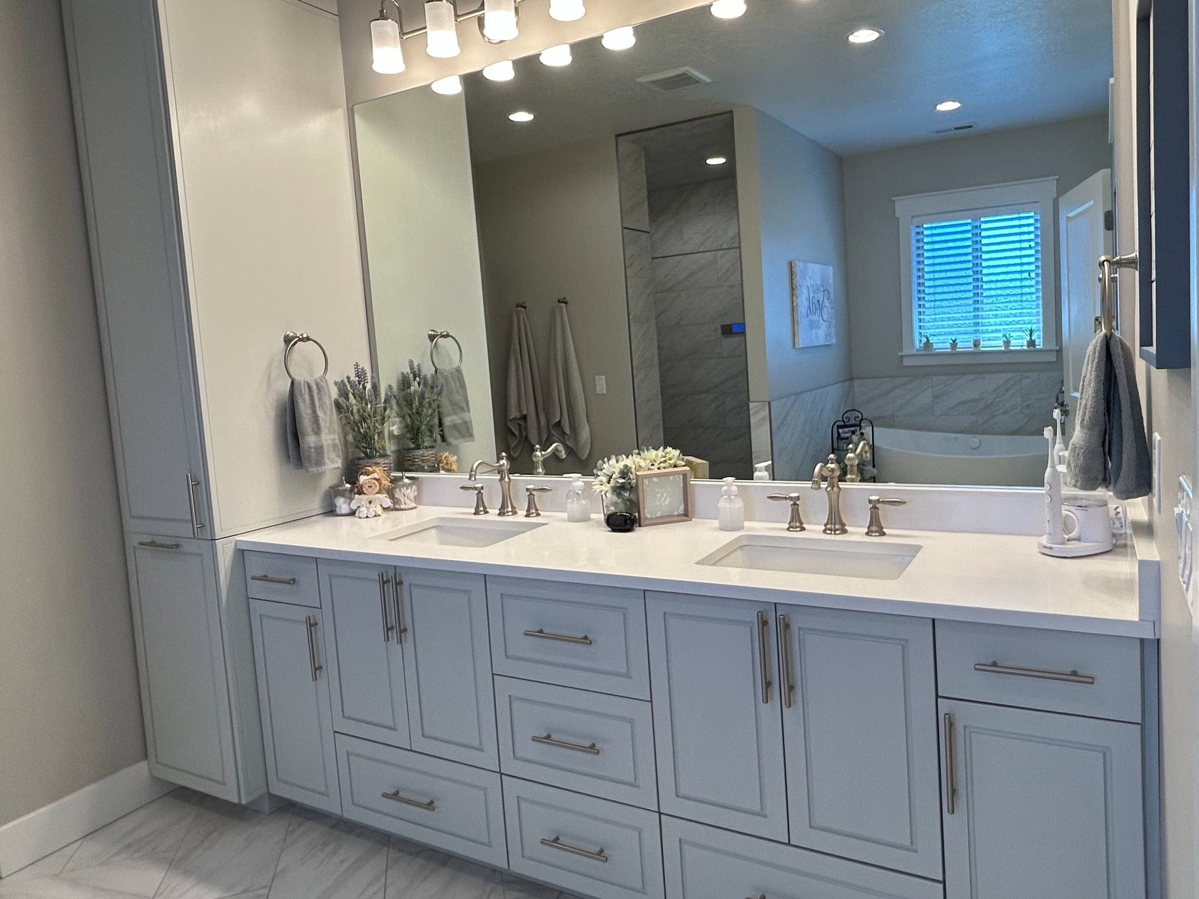Dual vanity with light-toned cabinetry, integrated sinks, and polished hardware