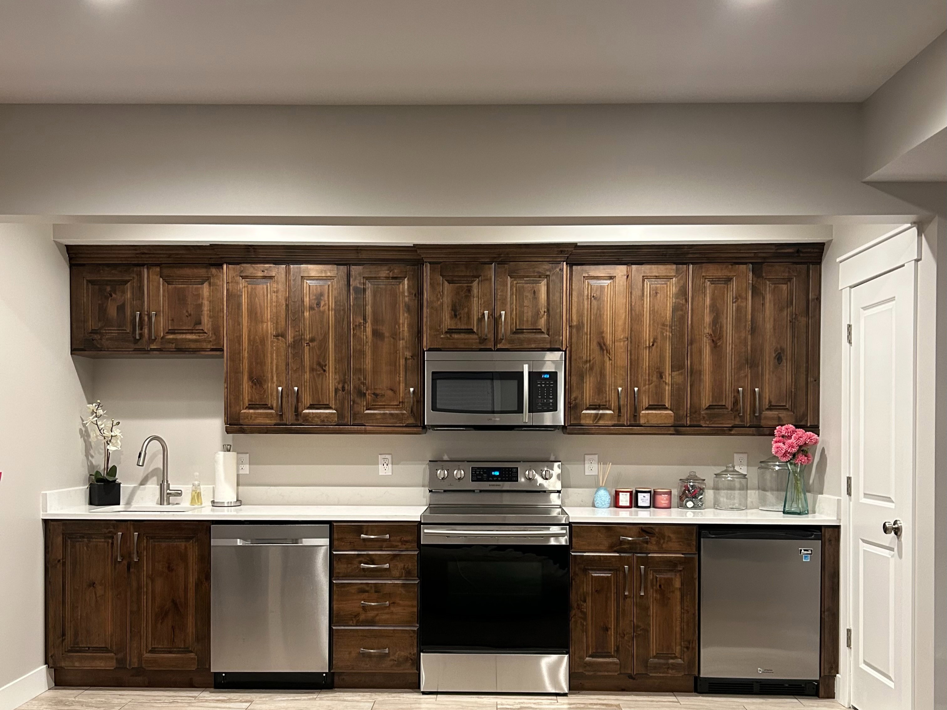 Full kitchen featuring rich wood cabinetry, stainless steel appliances, white countertops, and recessed lighting