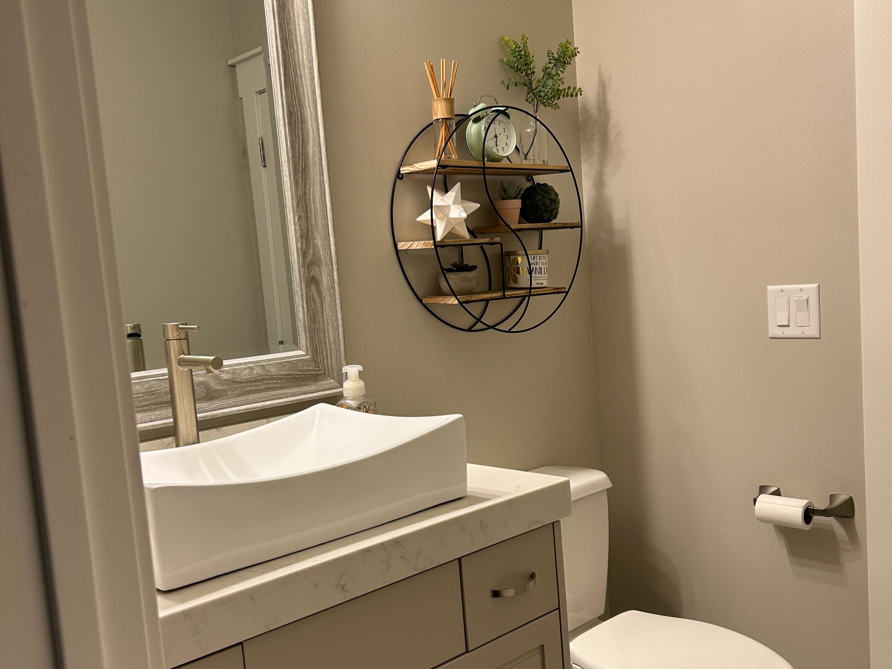 Modern vanity with a rectangular vessel sink, solid surface countertop, and brushed nickel faucet