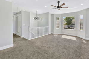 Spacious room featuring a tiered bay window, contemporary ceiling fan, recessed lighting, and soft grey carpeting