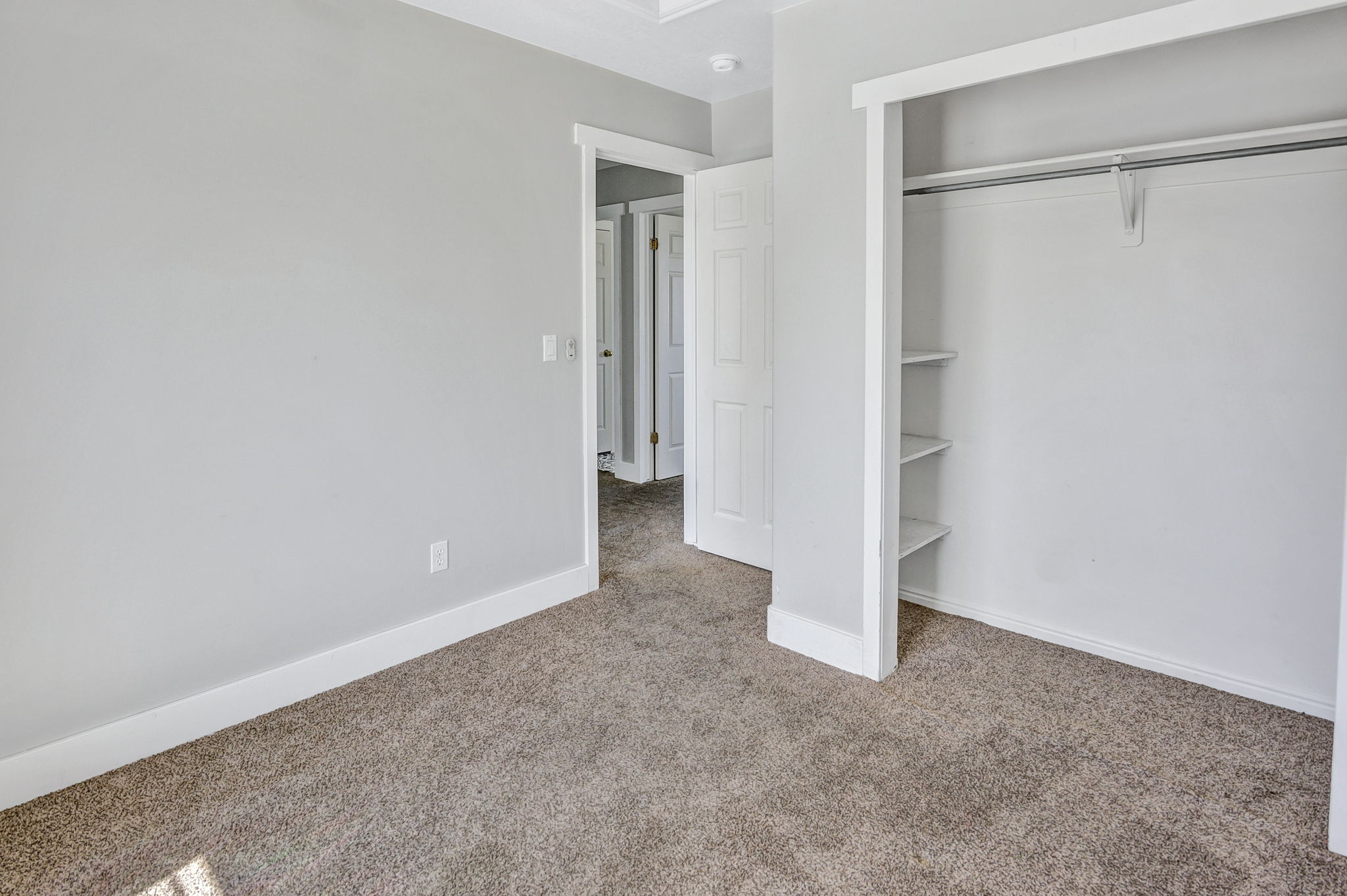Carpeted room featuring light gray walls and white baseboards