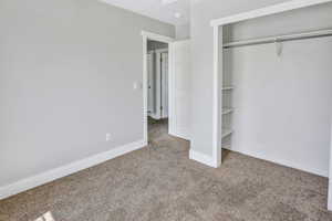 Carpeted room featuring light gray walls and white baseboards