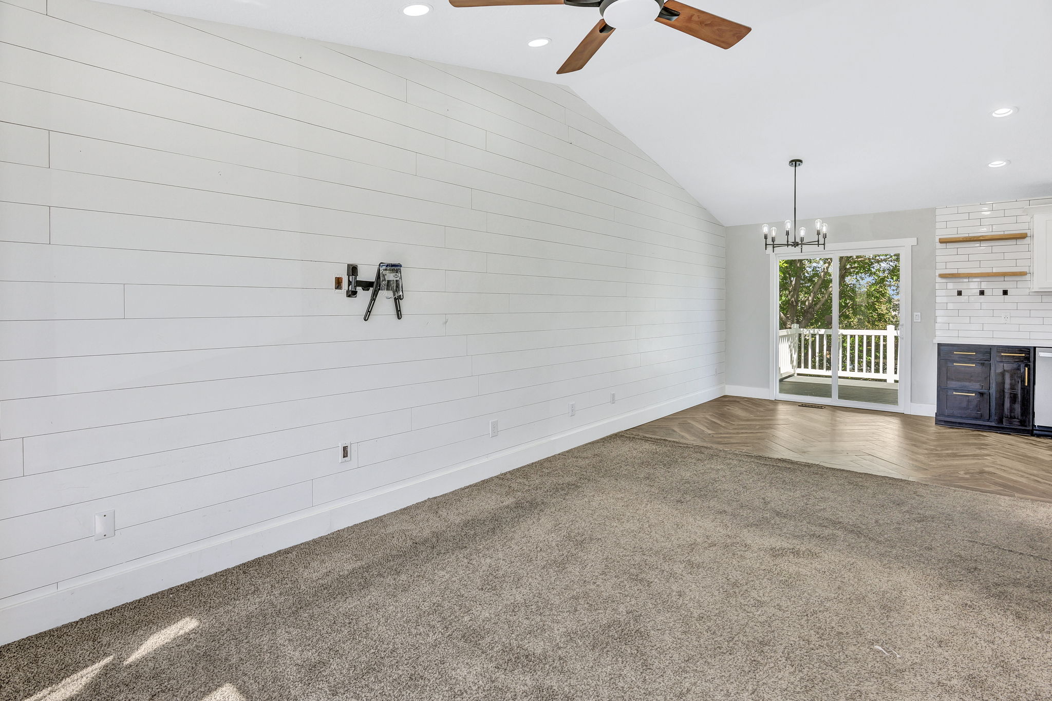 Vaulted ceiling with wood-finish ceiling fan and recessed lighting