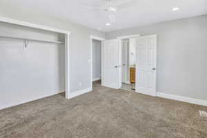 Spacious room featuring neutral carpeting, light gray wall paint, and white trim