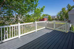 Spacious outdoor deck featuring dark-toned composite decking, white railing, and a gate