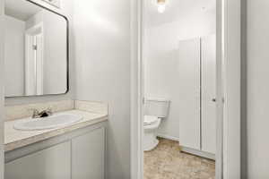 Bathroom vanity featuring a built-in sink with chrome faucet, light-toned countertop, and cabinet storage