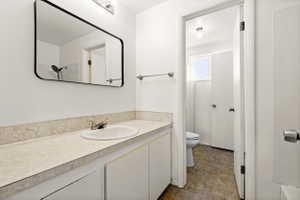 Bathroom vanity featuring a rectangular framed mirror, chrome faucet, and integrated sink