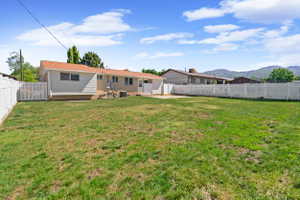 Expansive grassy yard area with a white picket fence perimeter