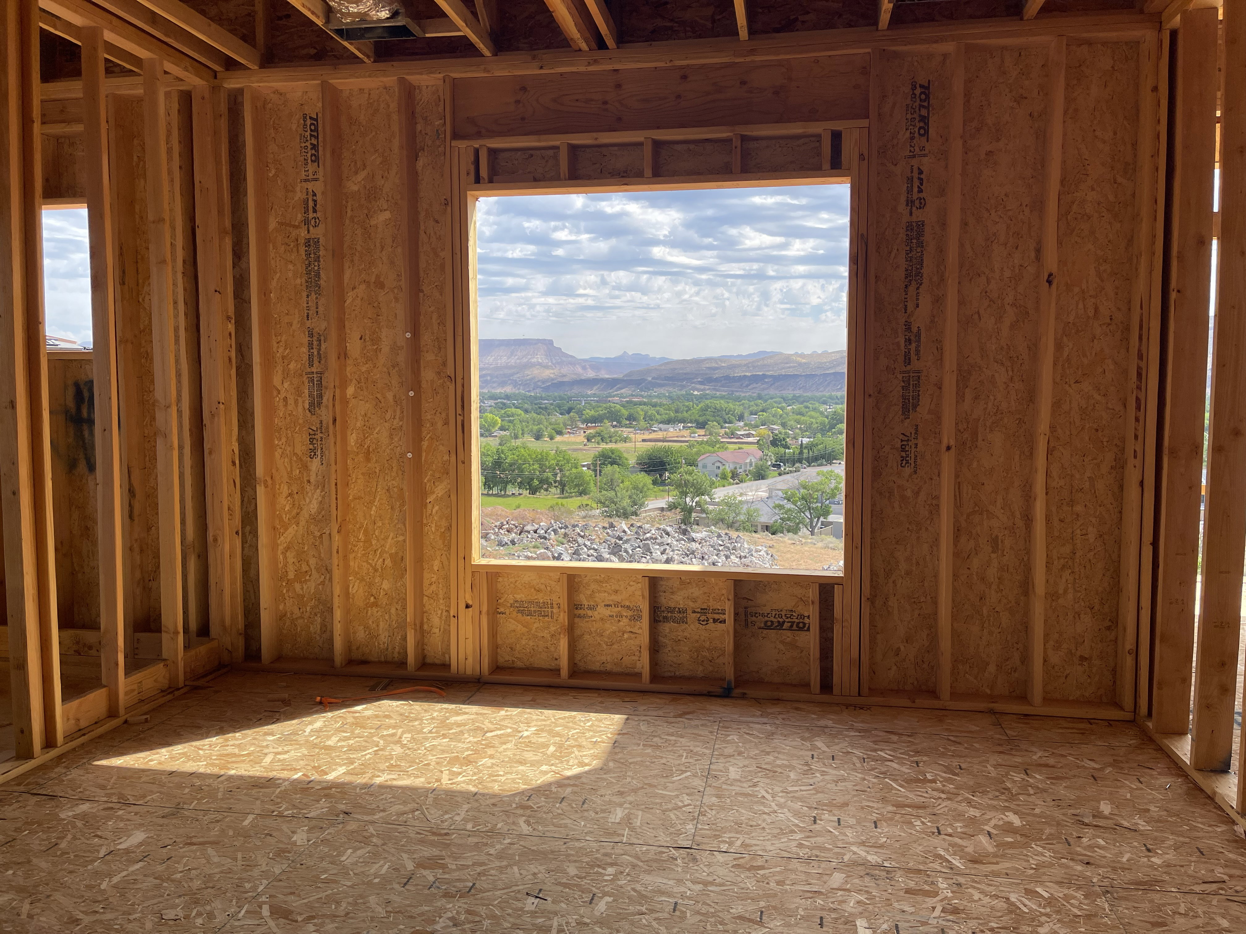 Framed interior room with expansive window opening showcasing distant mountains and surrounding greenery