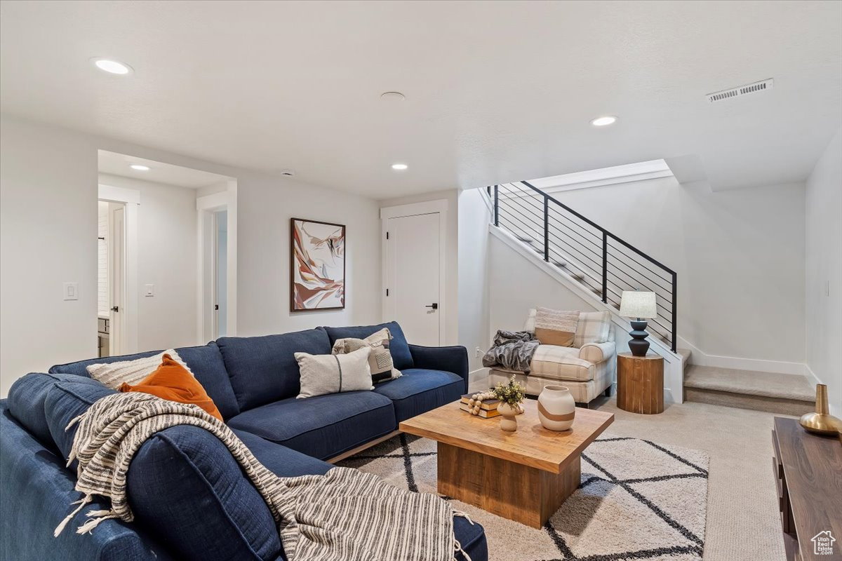 Spacious living area featuring recessed lighting, light neutral wall paint, and carpet flooring
