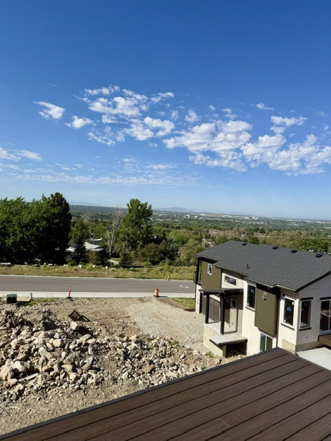 Modern construction featuring a multi-level design with dark shingle roofing, contrasting siding, and a covered entry