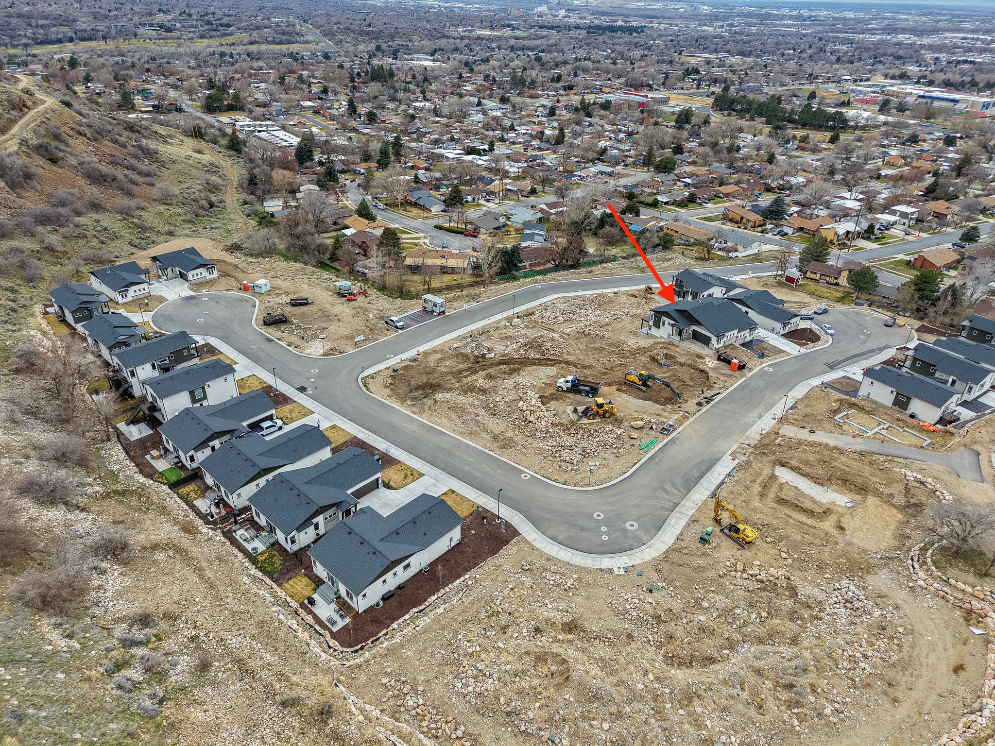 New construction community featuring modern residences with dark roofing, light-toned siding, and attached garages