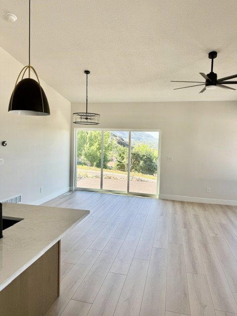 Open-concept living area with light wood-finish flooring