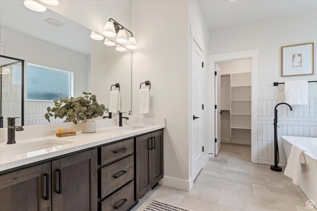 Dual vanity with dark wood-finish cabinetry, white countertops, and matte black fixtures