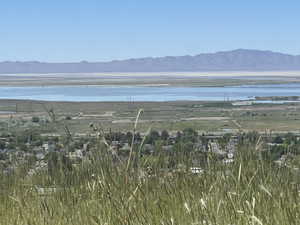 Scenic landscape featuring distant mountains, a large body of water, and a residential area with visible rooftops