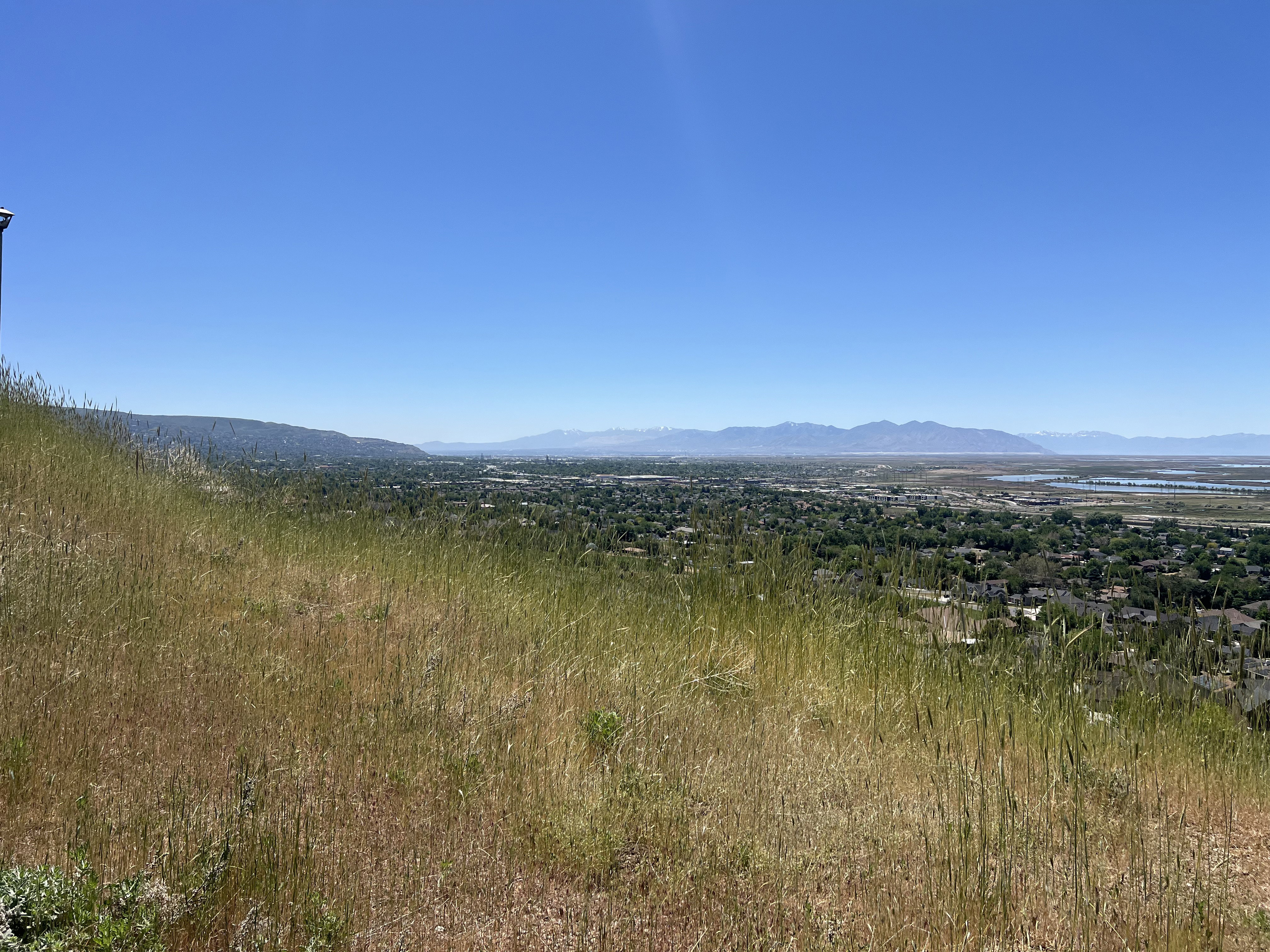 Expansive hillside lot featuring natural grasses and panoramic vistas of the distant mountains and valley below