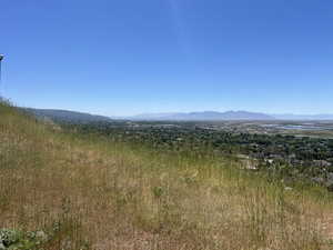 Expansive hillside lot featuring natural grasses and panoramic vistas of the distant mountains and valley below