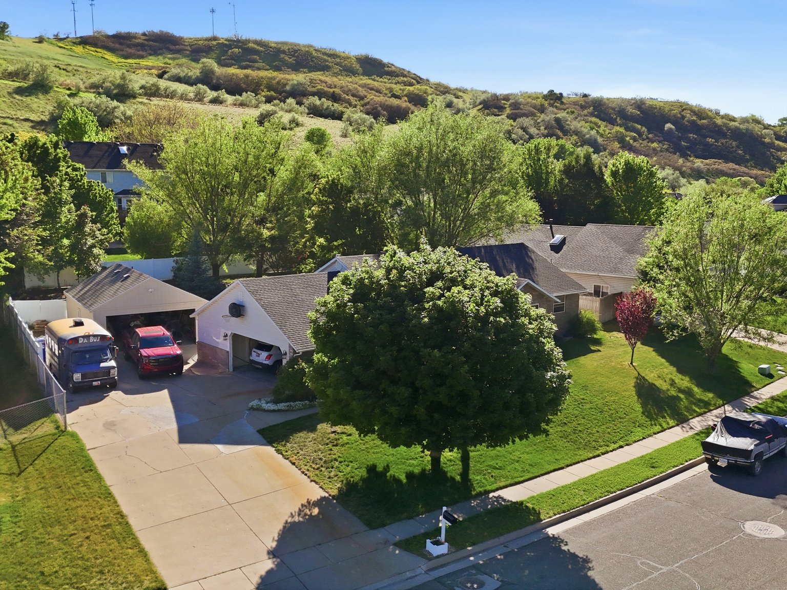 Suburban property featuring a multi-car driveway, attached garage, and mature landscaping