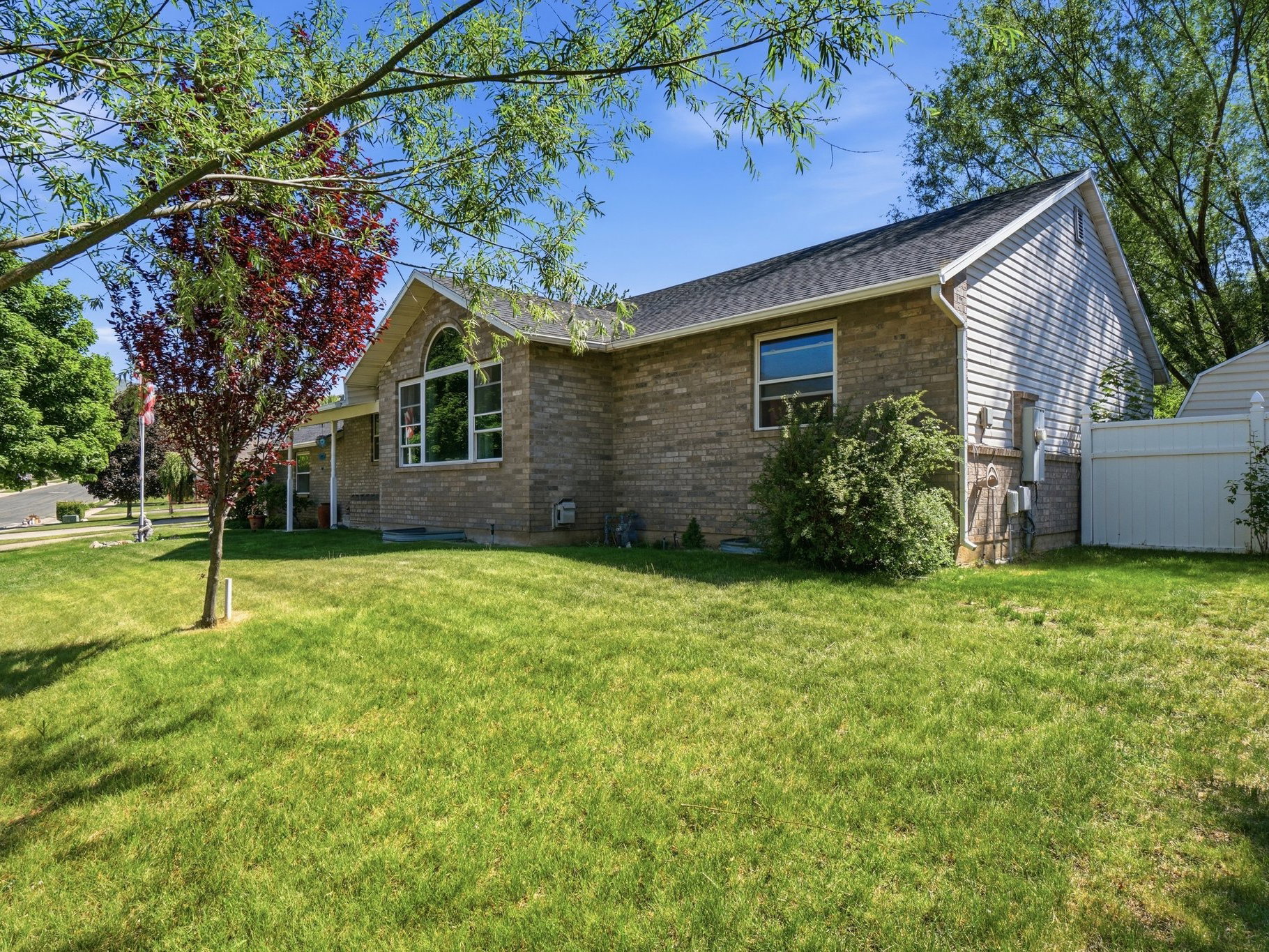 Brick and siding exterior featuring a prominent arched window