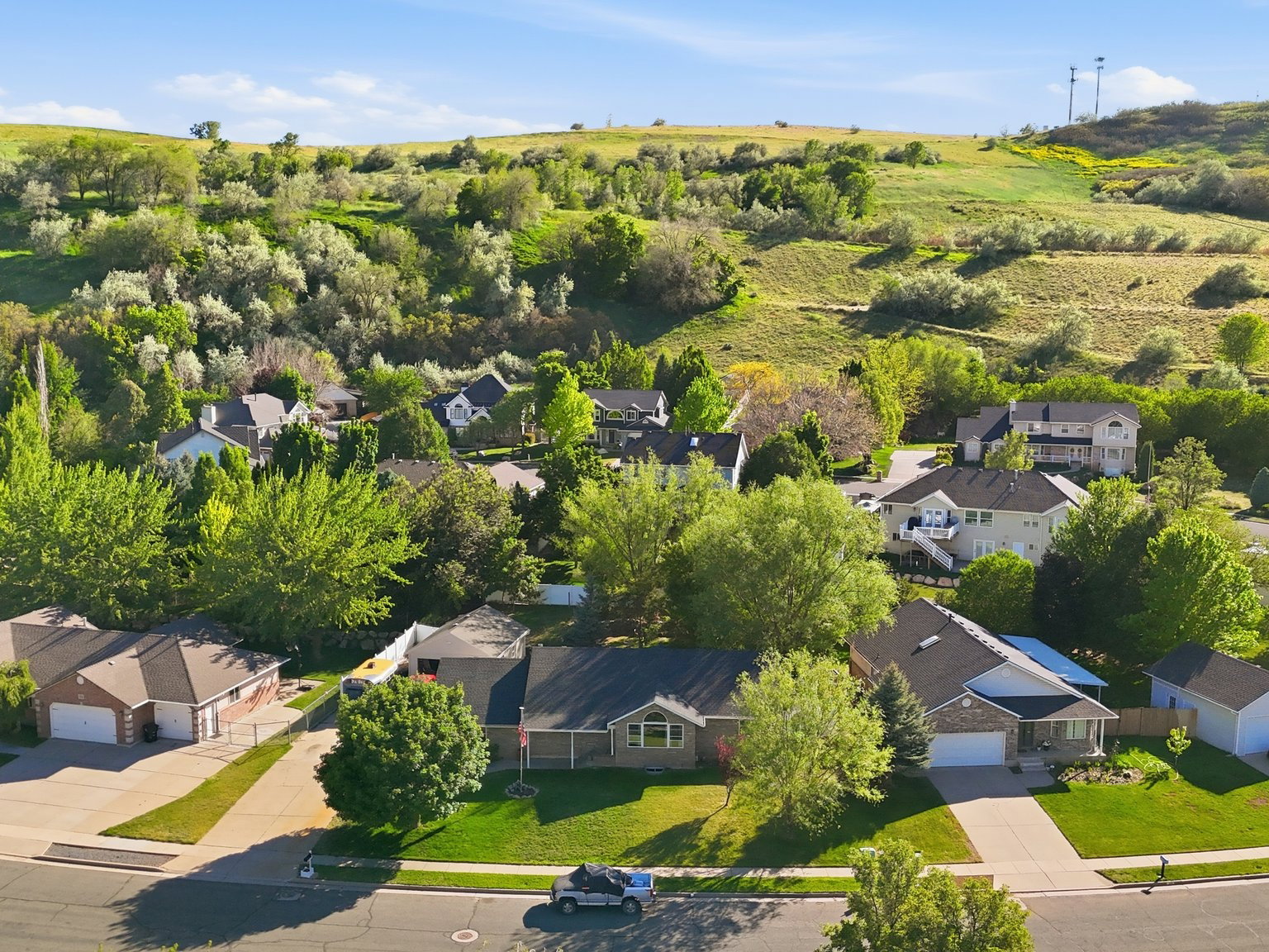 Residential neighborhood with a variety of architectural styles, mature trees, and landscaped front yards