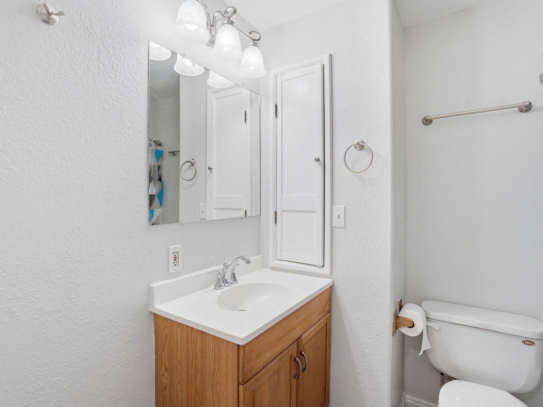 Bathroom featuring a light wood-finish vanity with a white countertop and integrated sink
