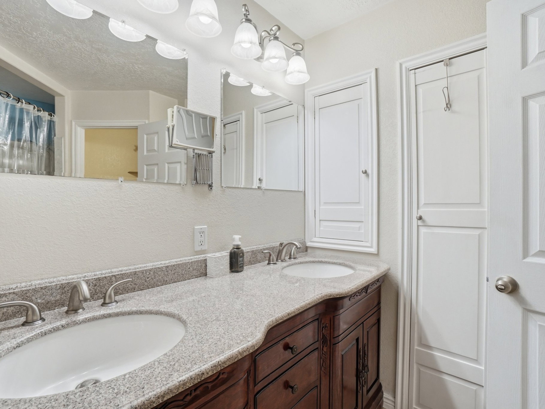 Dual vanity with light-toned countertop, undermount sinks, and brushed nickel faucets