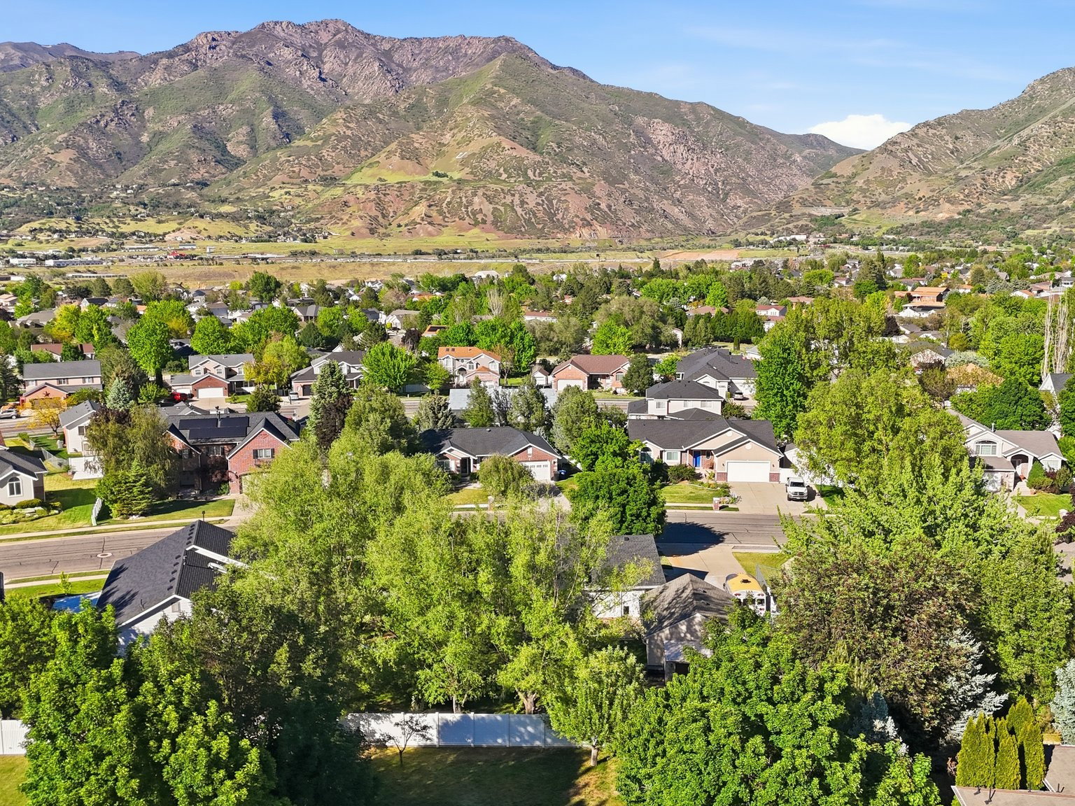 Aerial perspective showcasing a residential community with mature landscaping and mountain backdrops