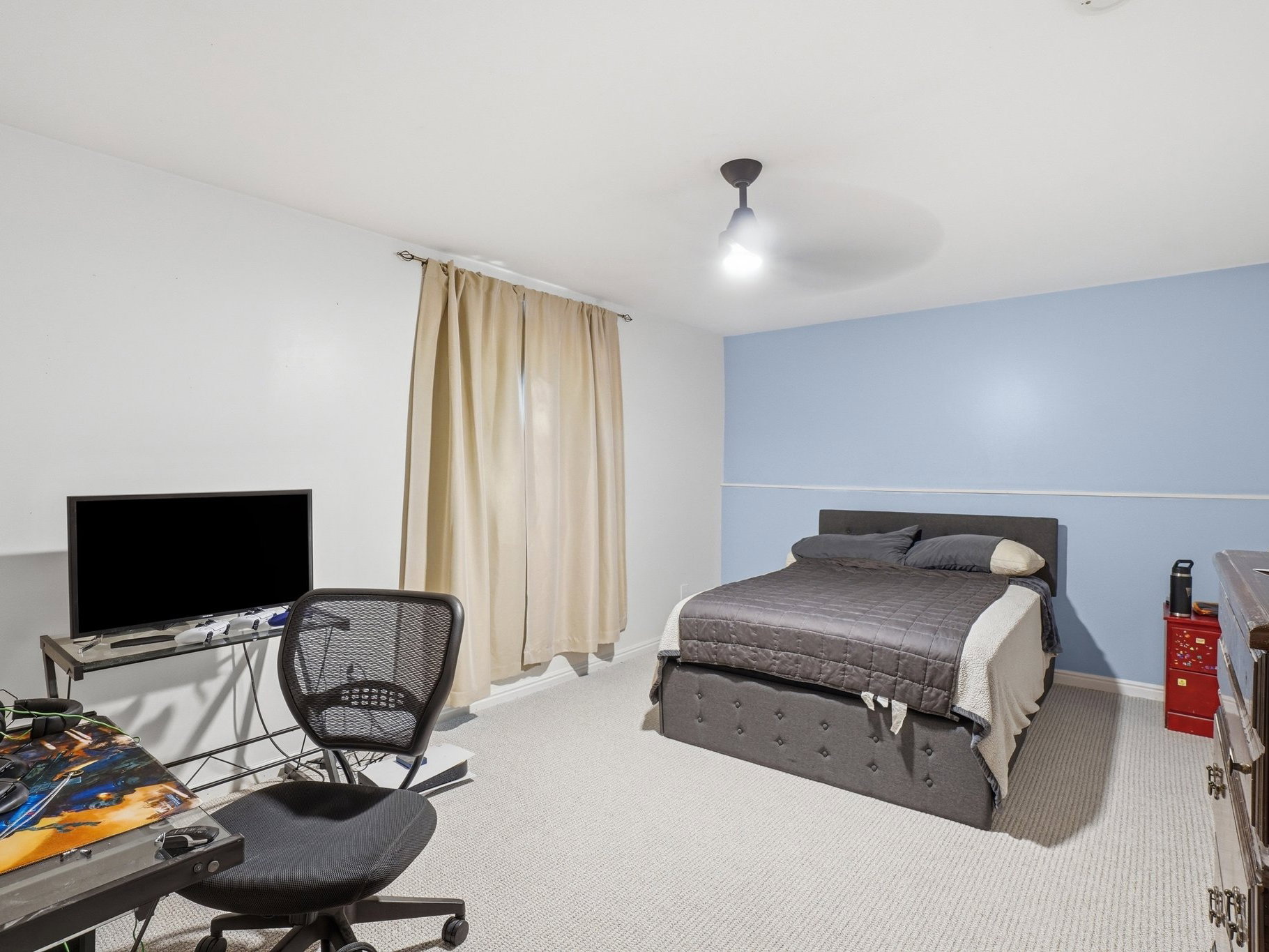 Bedroom with light blue and white two-tone wall treatment, light neutral carpeting, and a ceiling-mounted light fixture
